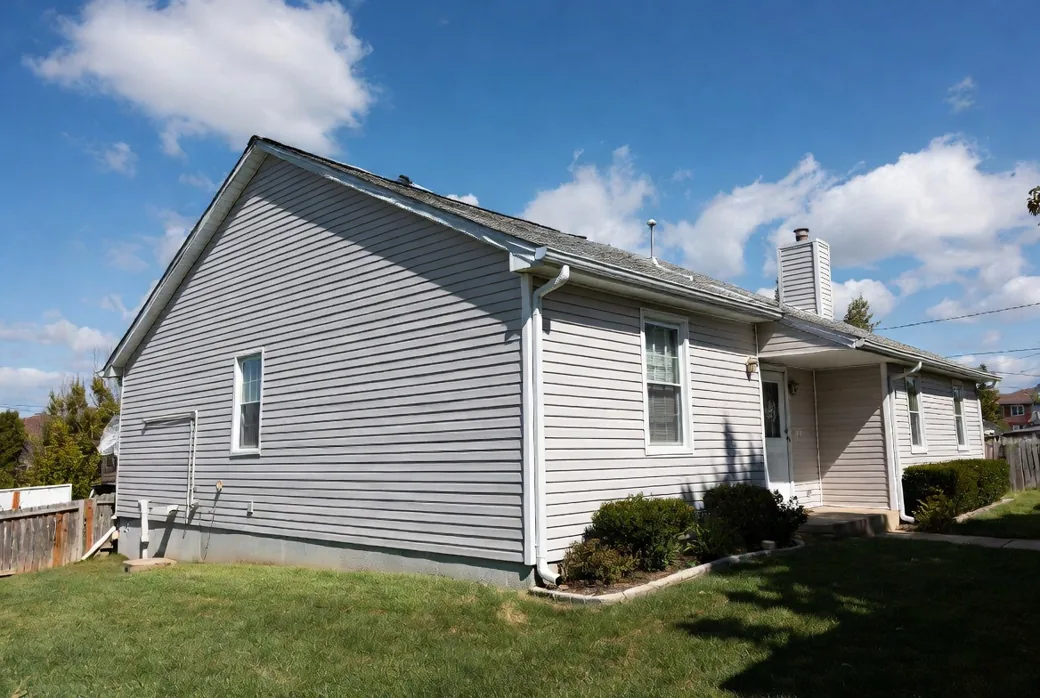 Typical American suburban house with clean white gutters and a downspout